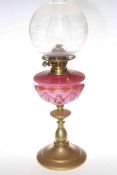 Victorian brass oil lamp with pink decorated glass reservoir and etched and frosted glass shade.