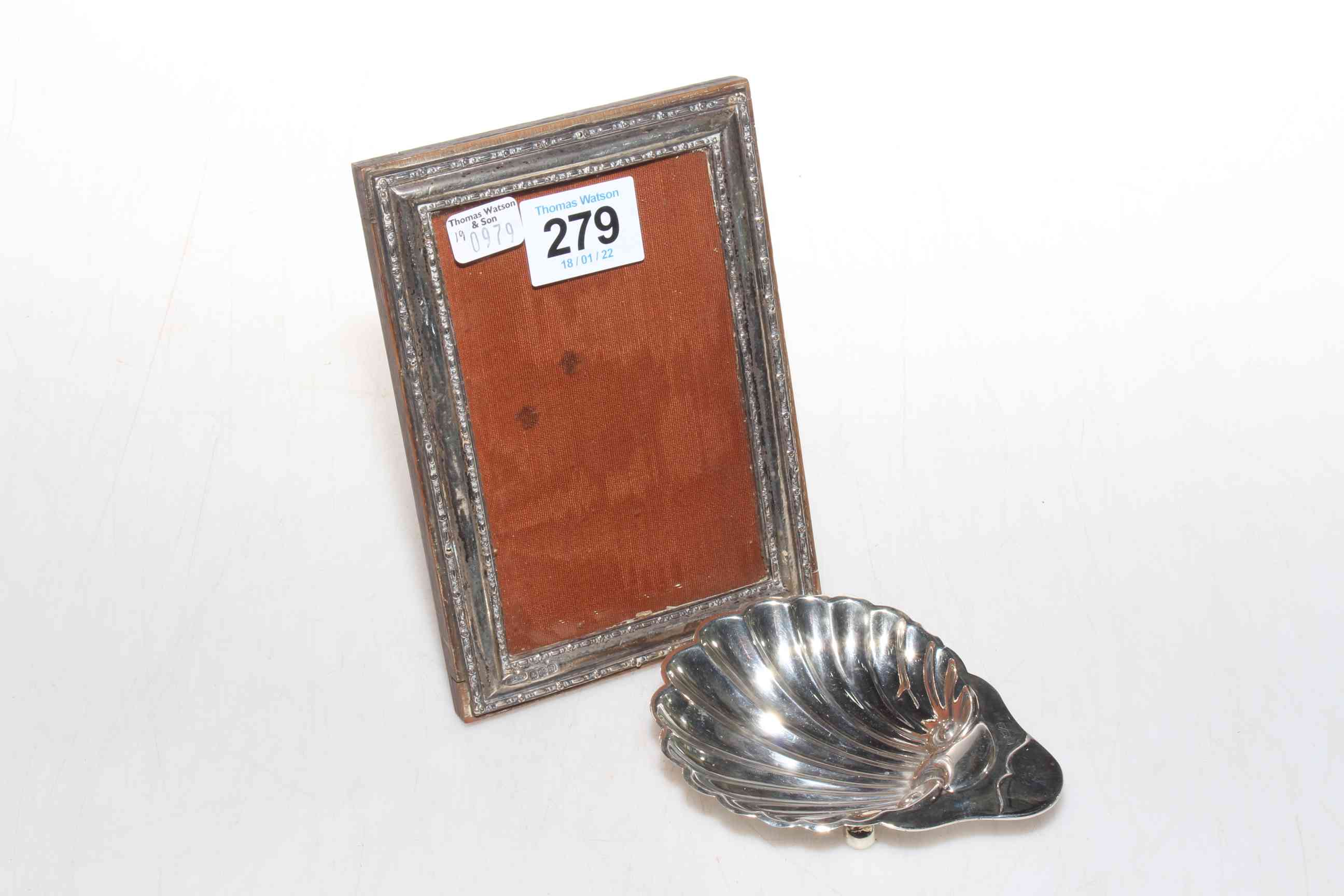 Silver photograph frame and small silver shell dish.