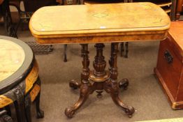 Victorian inlaid walnut fold top card table on four turned pillars to four scrolled feet,