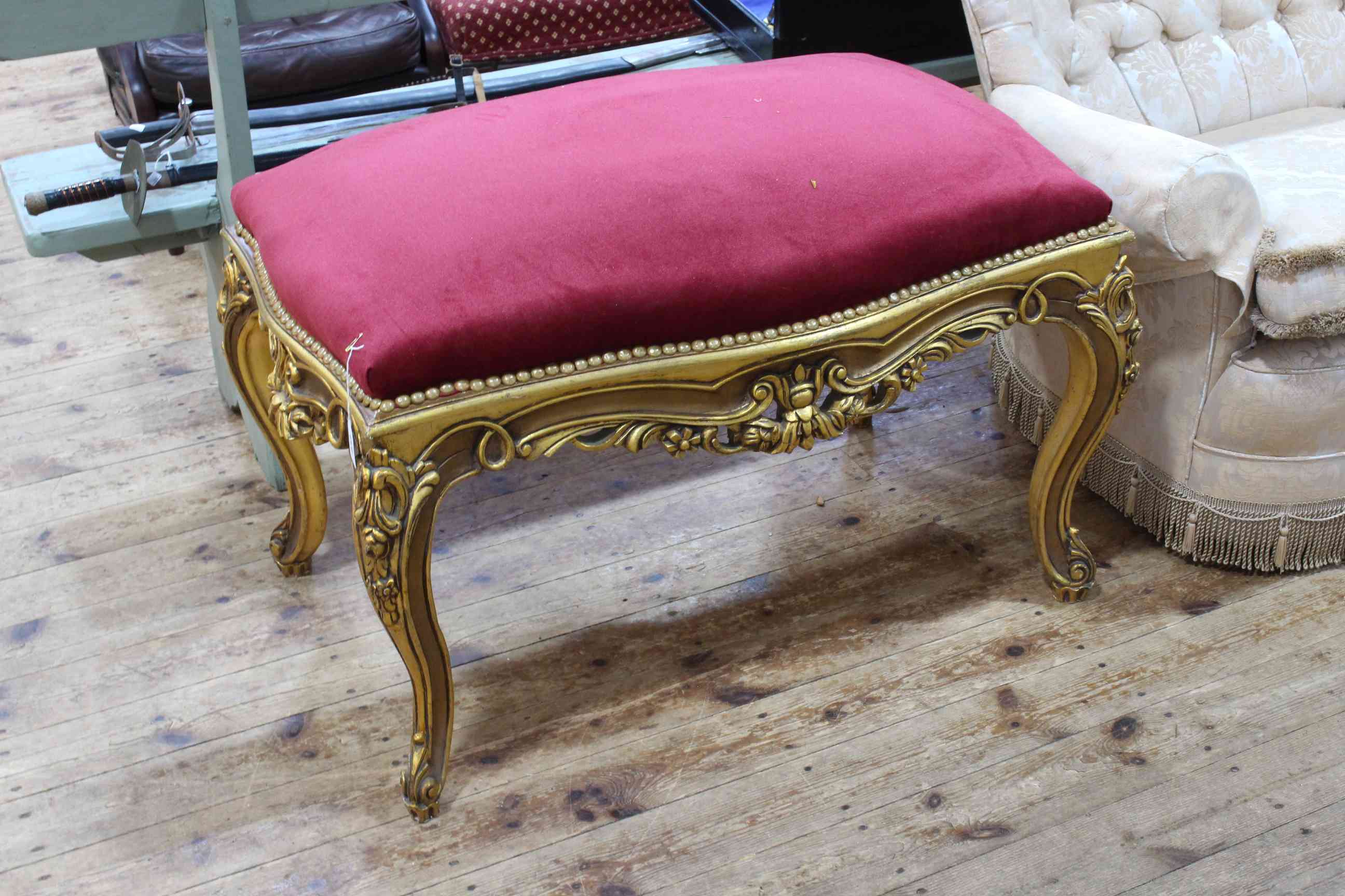 Giltwood stool of serpentine form.