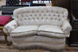 Kidney shaped two seater settee in classical button backed fabric.