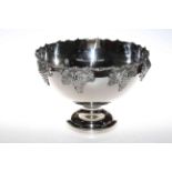 Large silvered metal pedestal punch bowl decorate with grape and vine, 27cm high by 38cm deep.