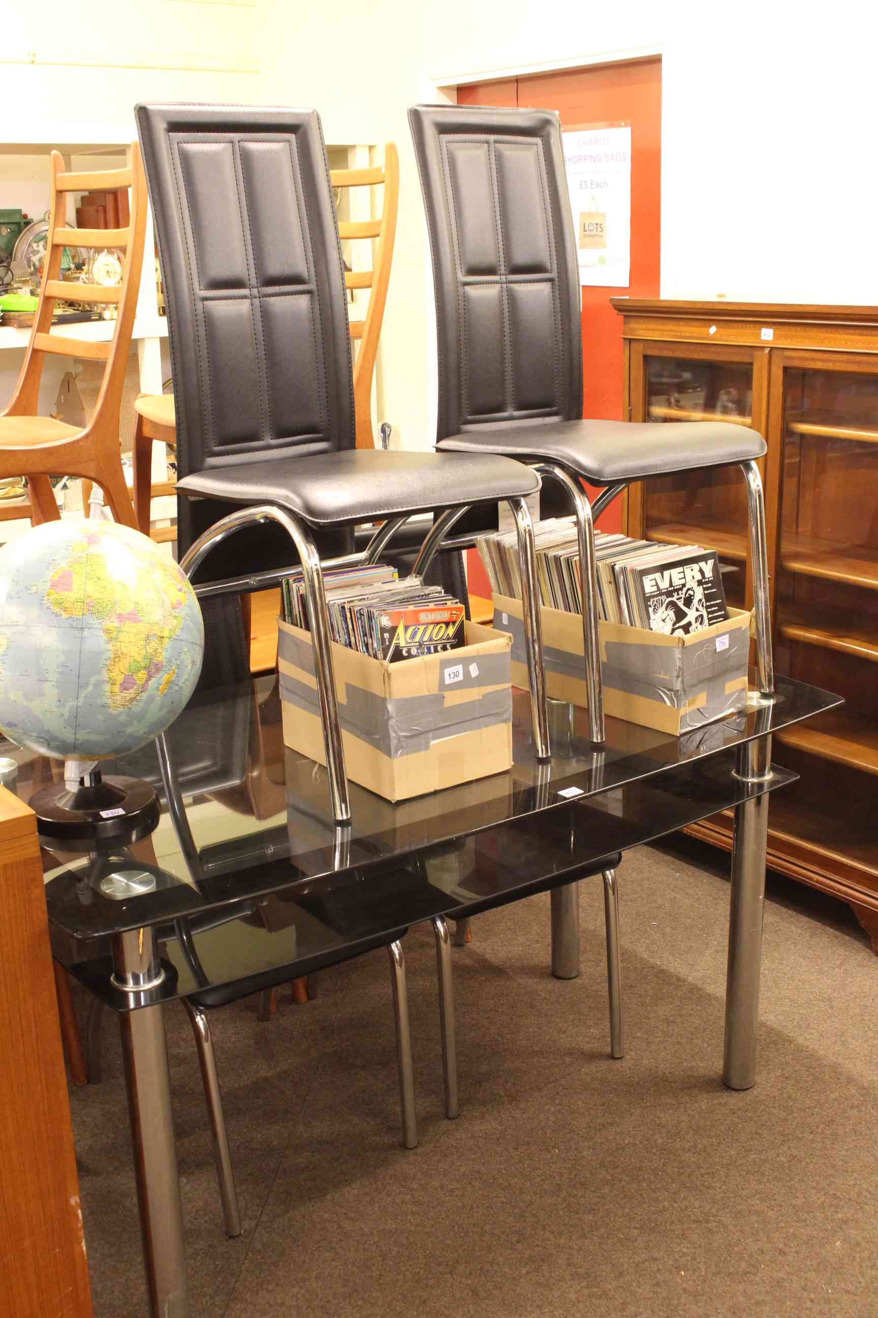 Contemporary two-tier glazed top dining table and four chairs.