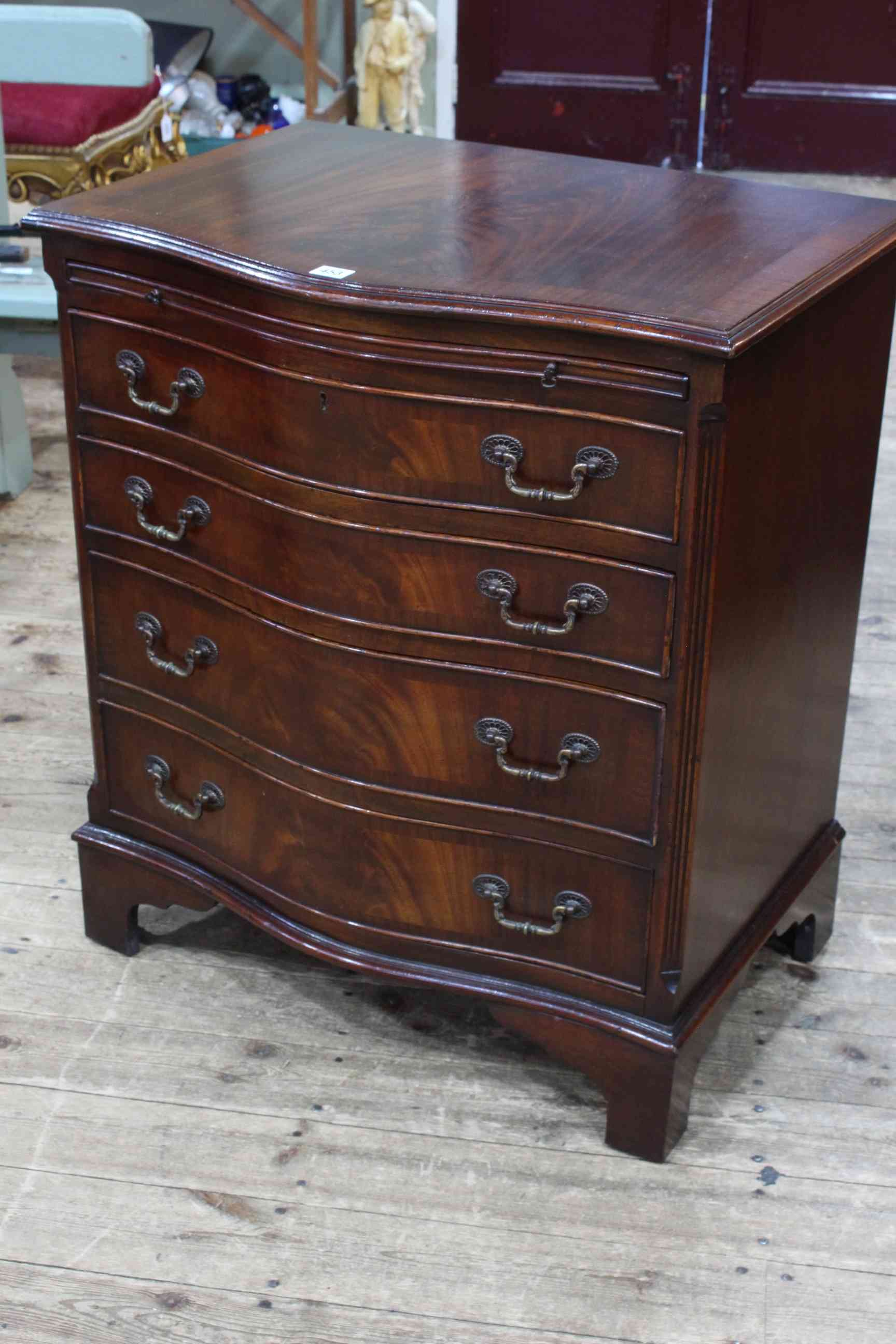 Mahogany serpentine front chest having brush slide above four long drawers on bracket feet,