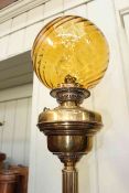 Victorian brass oil lamp with an orange spiral glass shade, 78cm high.