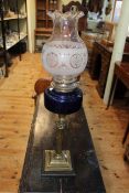 Victorian brass oil lamp with dark blue glass reservoir, 67cm high.