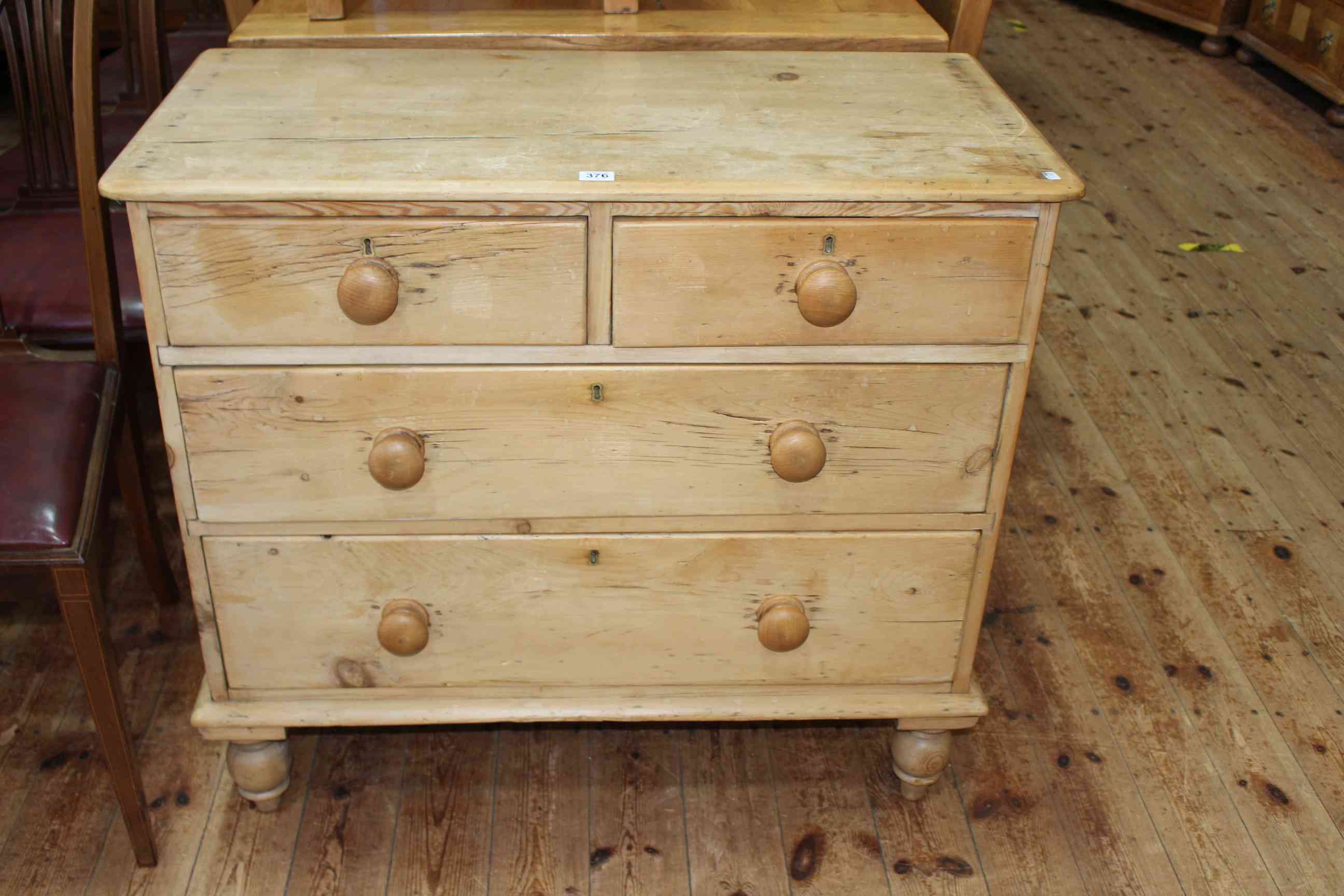 Stripped pine chest of two short above two long drawers on turned legs, 80cm by 91cm by 44cm.