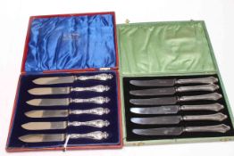 Two boxes of silver handled knives.