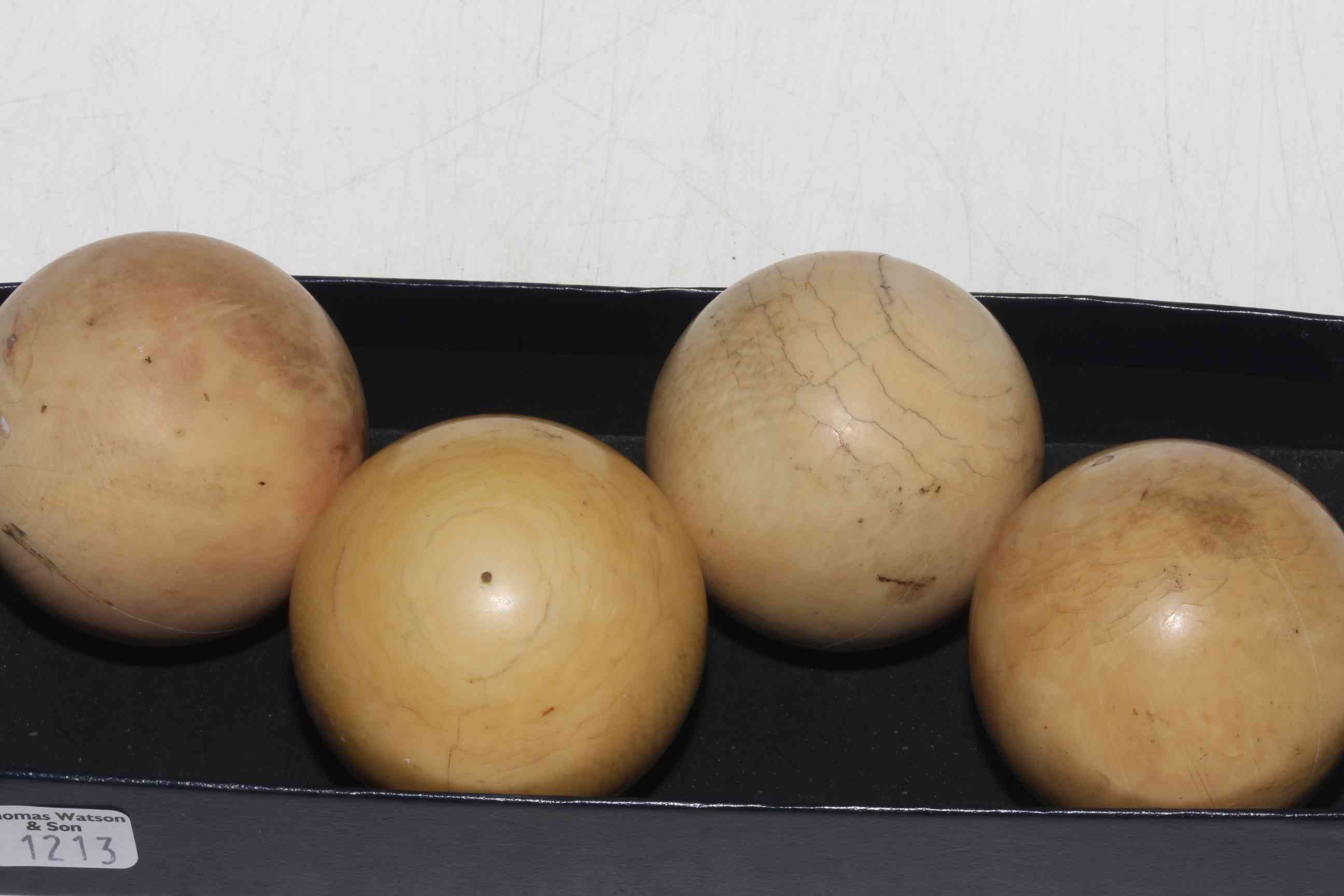 Four antique ivory snooker balls.