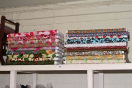 Nineteen rolls of floral pattern fabric of varying lengths.