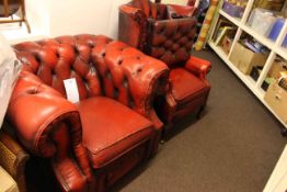 Red leather button backed Chesterfield armchair, wing back chair and footstool.