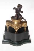 Bronze figure of a putti on a gilt ebonised and marble base, 24cm high.