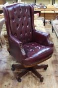Burgundy buttoned leather swivel office armchair.