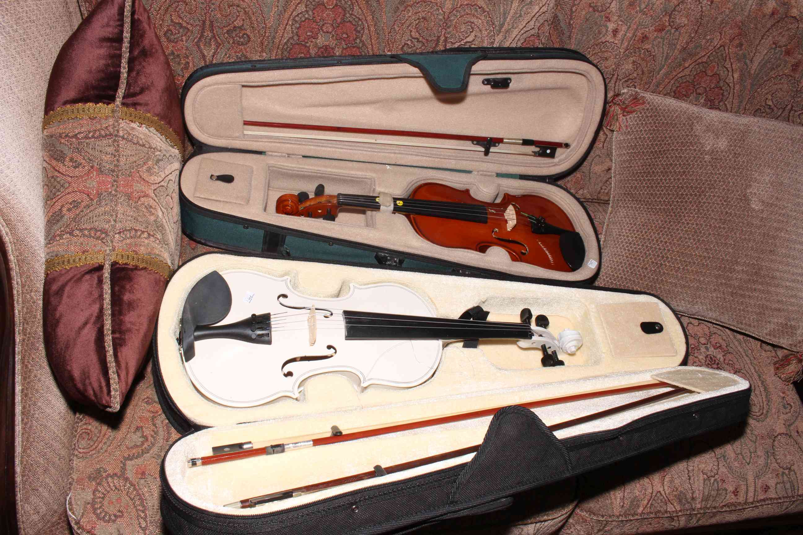 Two cased violins with bows.