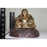 Brass model of a seated Buddha on wood plinth.