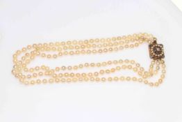 Three strand pearl necklace with 9 carat gold clasp set with sapphires and seed pearls, 40cm length.