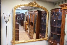 Arched top gilt framed overmantel mirror with shell and floral crest, 158cm by 162cm.