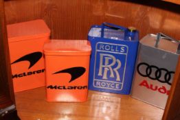 Two petrol cans with Audi and Rolls Royce designs, and two lidded tins with McLaren logo.