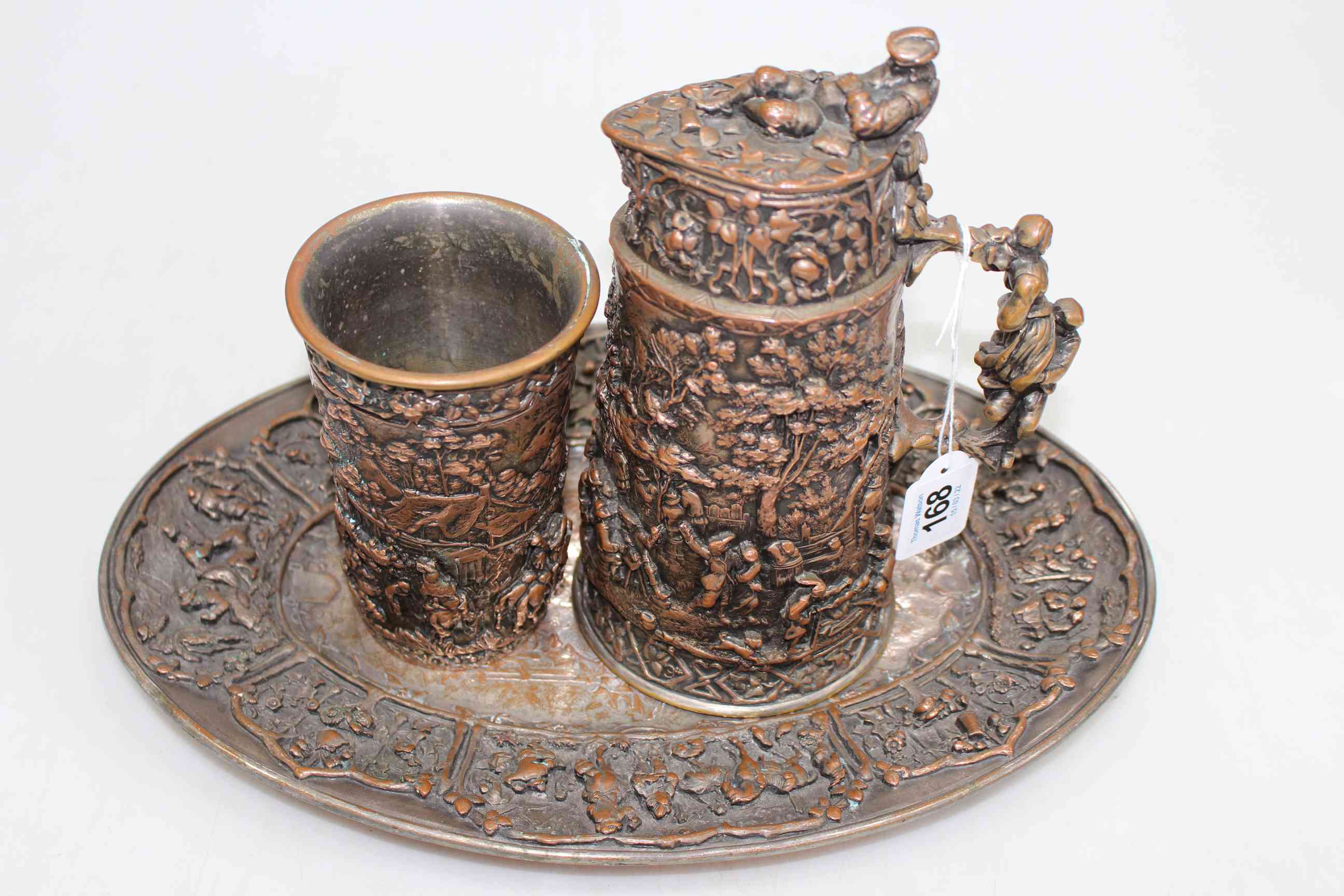 Continental highly decorative embossed copper jug, beaker and tray.