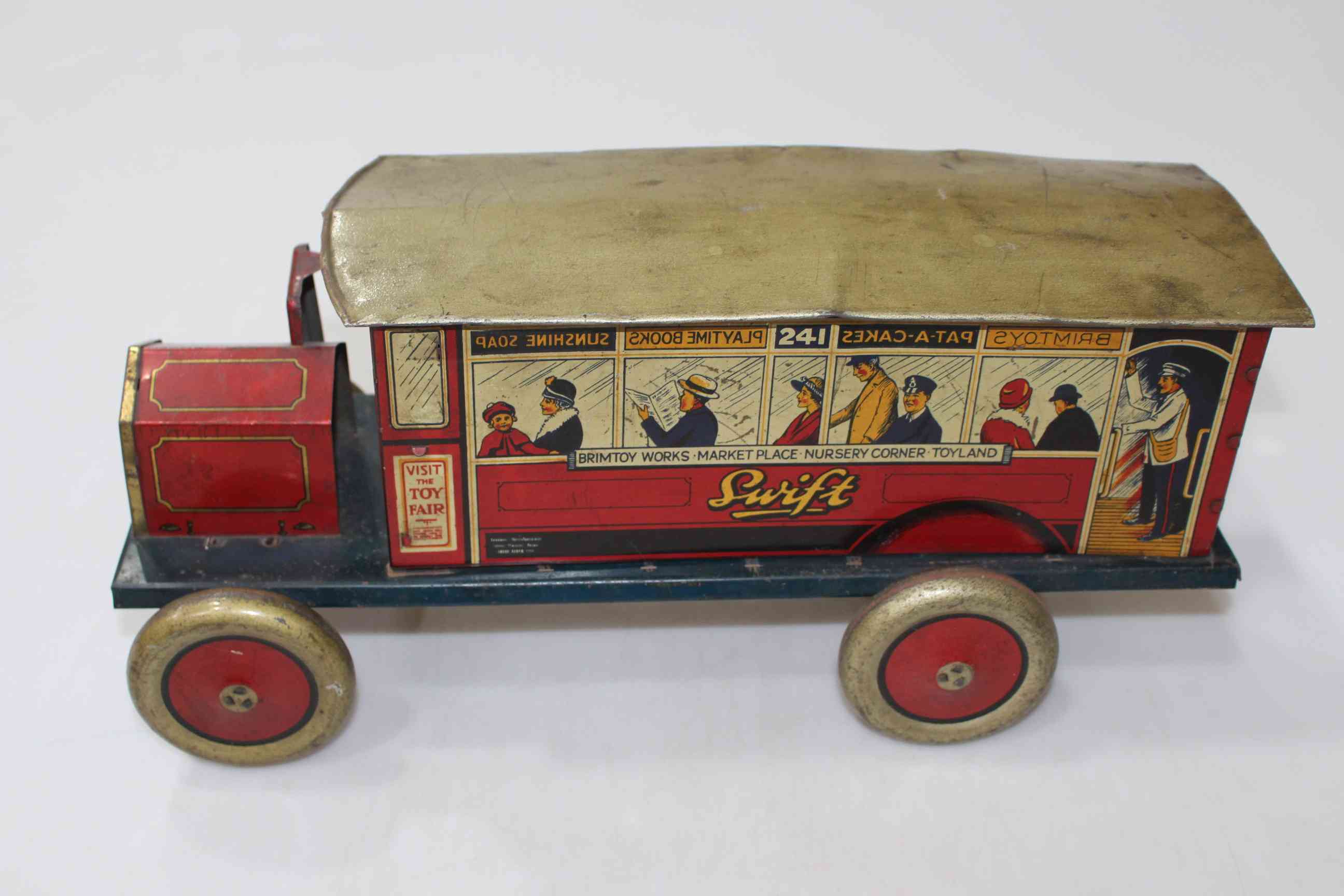 Swift tinplate bus with transfer decoration of passengers and conductor, 43cm length.