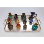 Collection of twelve Linthorpe and other similar small vases and candle holder.