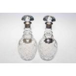 Pair of silver collared crystal decanters, London 1973, with silver Whisky and plated Brandy labels.