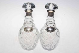 Pair of silver collared crystal decanters, London 1973, with silver Whisky and plated Brandy labels.