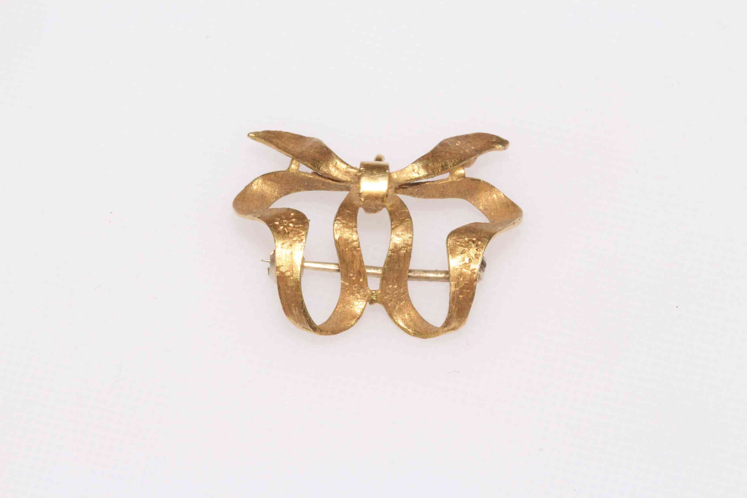 18 carat gold ribbon bow brooch, 3cm across.