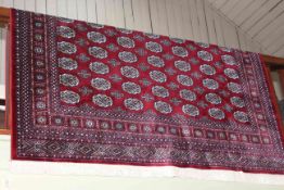 Bokhara carpet with a red ground 3.00 by 2.00.