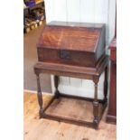Antique oak slope front bible box on turned leg stand, 95cm by 65cm by 45cm.