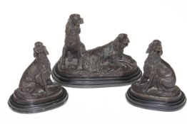 Set of three bronze spaniel sculptures, on marble bases, largest 21cm high, 27cm across.