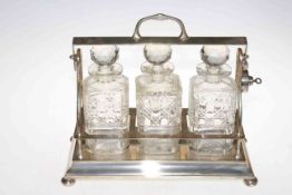 EPNS three bottle tantalus with crystal decanters (with key).