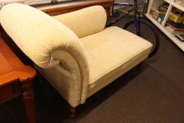 Modern chaise longue on turned legs in light yellow fabric.