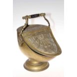 Heavily embossed brass coal scuttle with inset shovel.