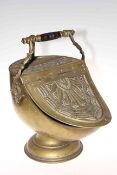 Heavily embossed brass coal scuttle with inset shovel.