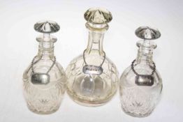 Three crystal decanters with silver plated spirit labels.