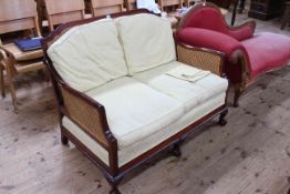 Early 20th Century mahogany and bergere panelled two seater settee on ball and claw legs.