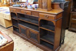 Late Victorian mahogany cabinet bookcase having three drawers above open shelves and two carved