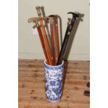 Collection of walking sticks with stand including brass handled.