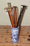 Collection of walking sticks with stand including brass handled.