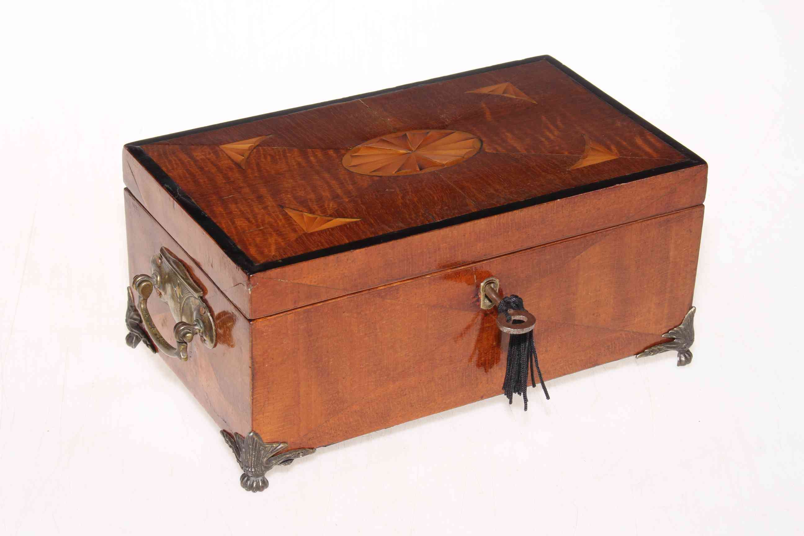 Inlaid mahogany trinket box on brass paw feet and containing collection of vintage keys,