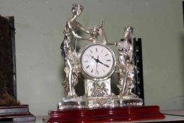 Silver coloured figural mantel clock.