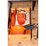 Three Le Creuset pans and lids, casserole dish, teapot, cream jug and wood crate.