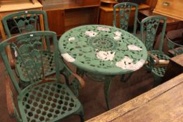 Aluminium circular patio table and set of four cast iron patio chairs.
