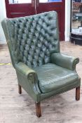 Georgian style wing armchair in green buttoned and studded leather.