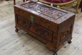 Oriental carved camphorwood trunk on claw feet, 49cm by 86cm by 41cm.