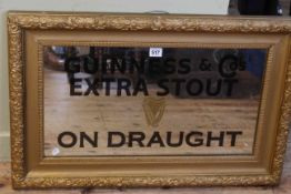 Rectangular gilt framed wall mirror painted Guinness & Co Extra Stout on Draught, 74cm by 49cm.