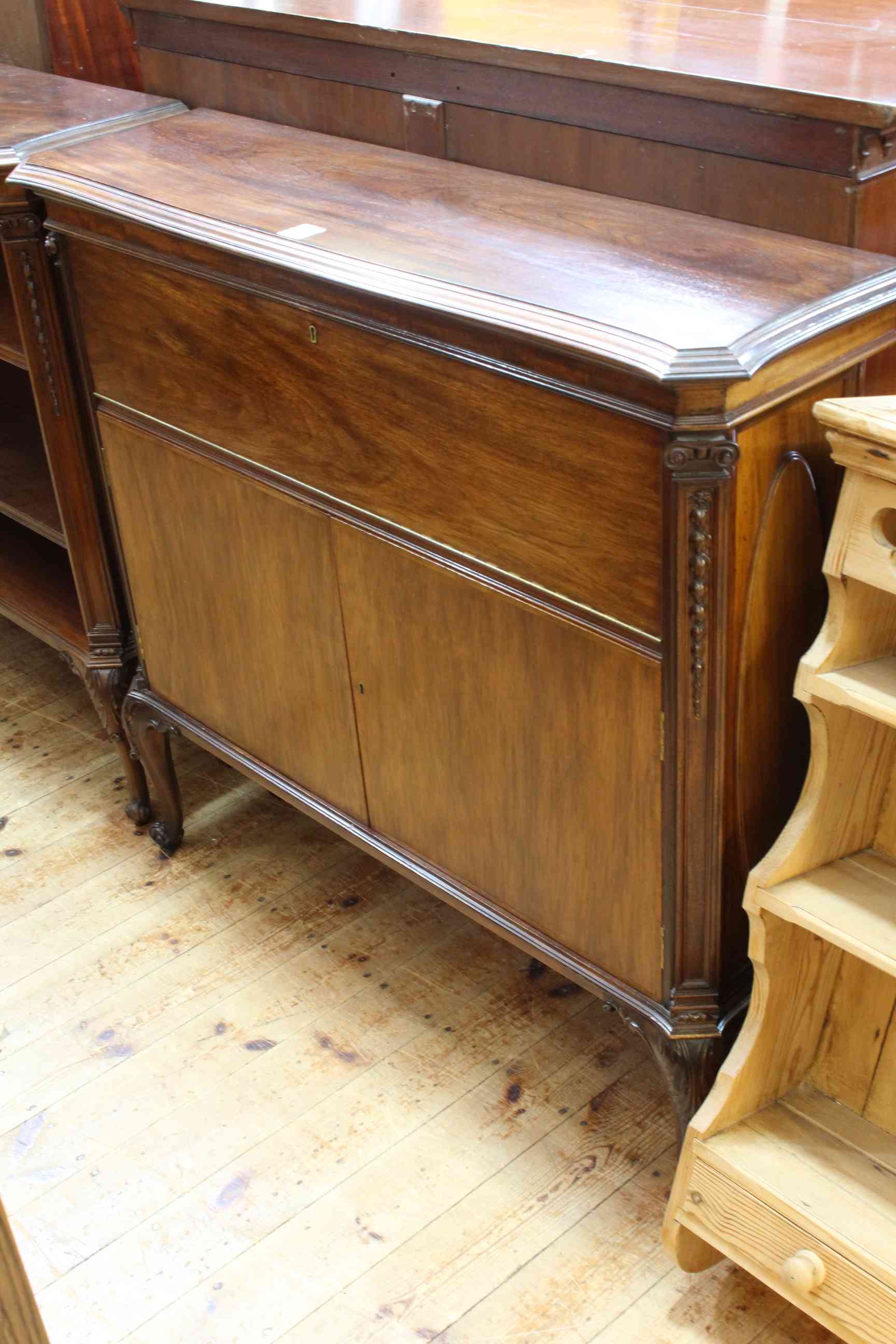 Mahogany shaped top cabinet having fall front above two cupboard doors on cabriole legs,