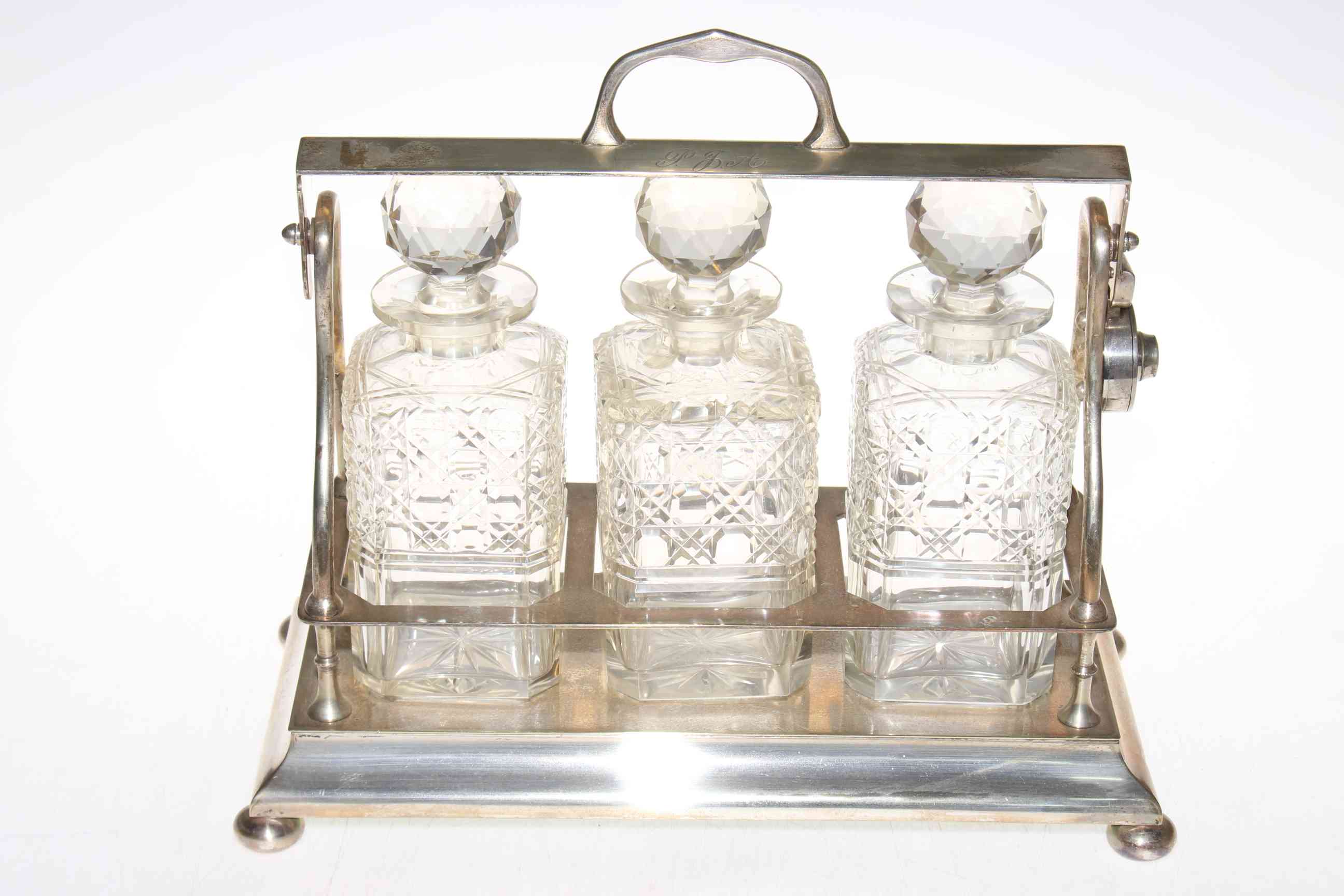 EPNS three bottle tantalus with crystal decanters (with key).