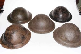 Five metal military helmets.